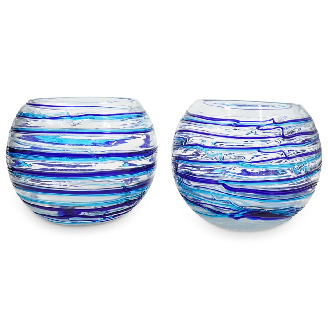 Pair Of Murano Glass Blue Reeded Bowls: DESCRIPTION: Two matching Murano glass bowls, each featuring blue and light blue reeding swirled around the exterior. CIRCA: 20th Century ORIGIN: Italy DIMENSIONS: H: 6.5" D: 8" CONDITION: Flea bite c