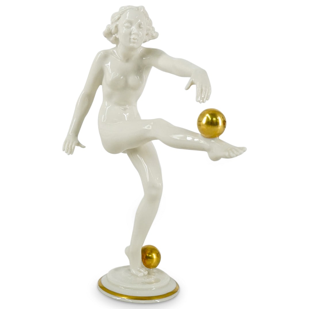 Vintage Hutschenreuther Porcelain Figure: DESCRIPTION: Art Deco-style porcelain figure by Hutschenreuther, designed by Carl Werner, depicting a nude woman with two golden balls. CIRCA: Mid 20th Century ORIGIN: German DIMENSIONS: H: 8.5" W: 3.