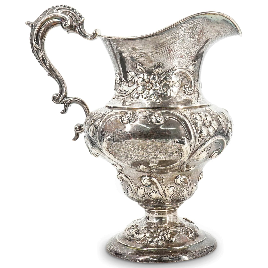 Black Starr & Frost Sterling Silver Water Pitcher: DESCRIPTION: Black Starr & Frost sterling silver water pitcher with flared pouring spout, acanthus formed handle, and floral repousse patterns throughout. Marked: "Black Starr & Frost, Sterling, 1342,