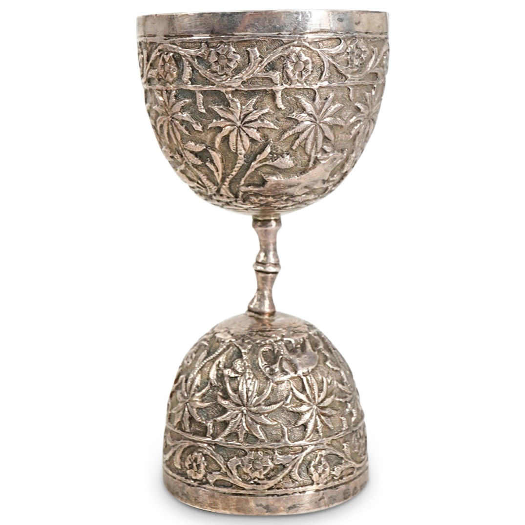 Antique Burmese Silver Jigger: DESCRIPTION: Antique silver jigger featuring repousse scenes of wild beasts among tropical foliage bordered by floral and foliage designs. Total weight: 62 g. CIRCA: 19th to early 20th Century ORIGIN: