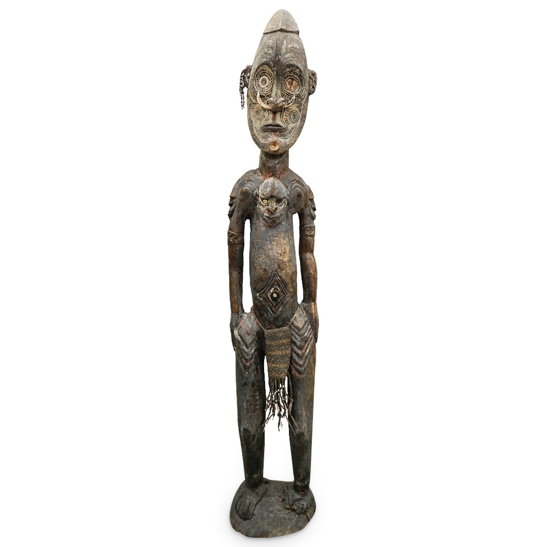Papua New Guinea Sawos Ancestral Figure: DESCRIPTION: Papua New Guinea Sawos Ancestral figure composed of carved wood with polychrome remnants along face and body, adorned with woven grass loin cloth, inset with boar tusk and puka shells. CI