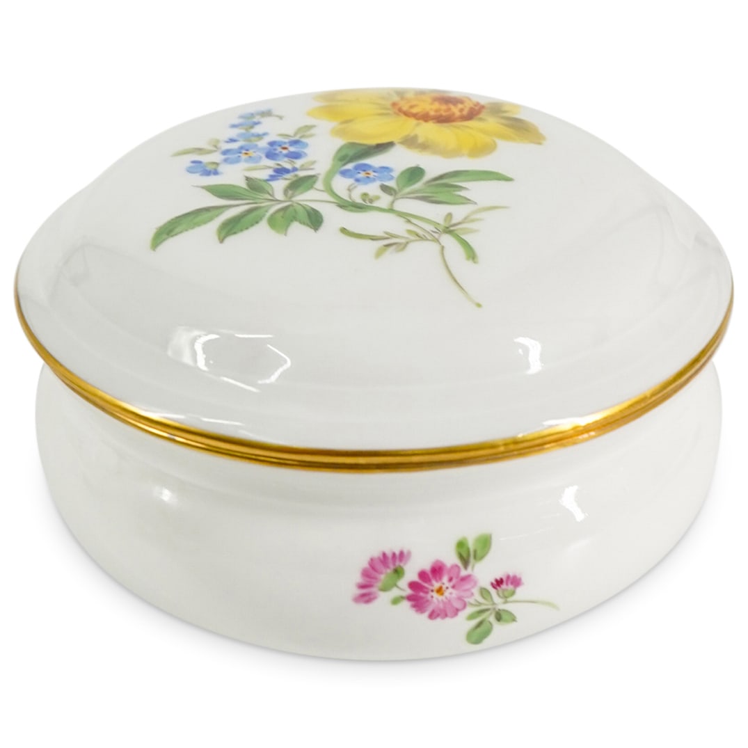 German Meissen Porcelain Lidded Box: DESCRIPTION: German Meissen Porcelain lidded box in white glazed porcelain embellished with vibrant hued floral motifs, and gilt rim. Marked with Meissen hallmark on the underside. CIRCA: 20th Century