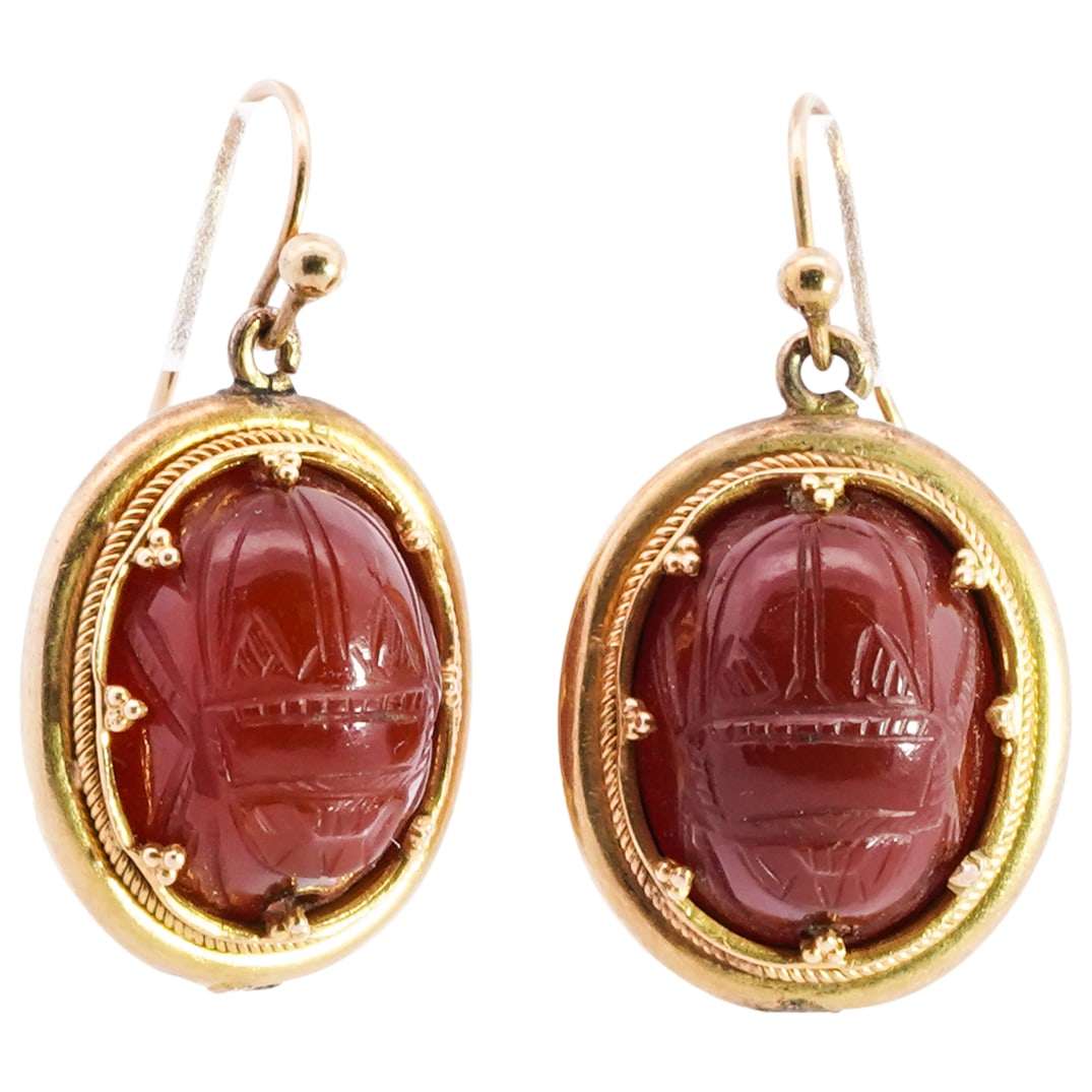 Egyptian Revival 18k Gold and Carnelian Scarab Earrings: DESCRIPTION: A pair of Egyptian revival earrings crafted with an 18k yellow gold frame centered by hand carved carnelian scarabs, further carved along the verso with hieroglyphic figures. Total Weight
