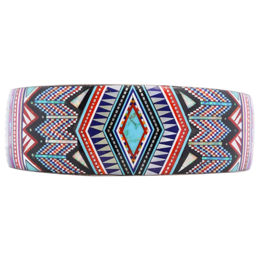 Excellent Southwest Native American Inset Sterling Silver Cuff: DESCRIPTION: A hand crafted southwest Native American sterling silver cuff excellently inlaid with a series of semi precious stones (Turquoise, MOP, Coral, Opal, Coral, Lapis and Jasper) overall formi