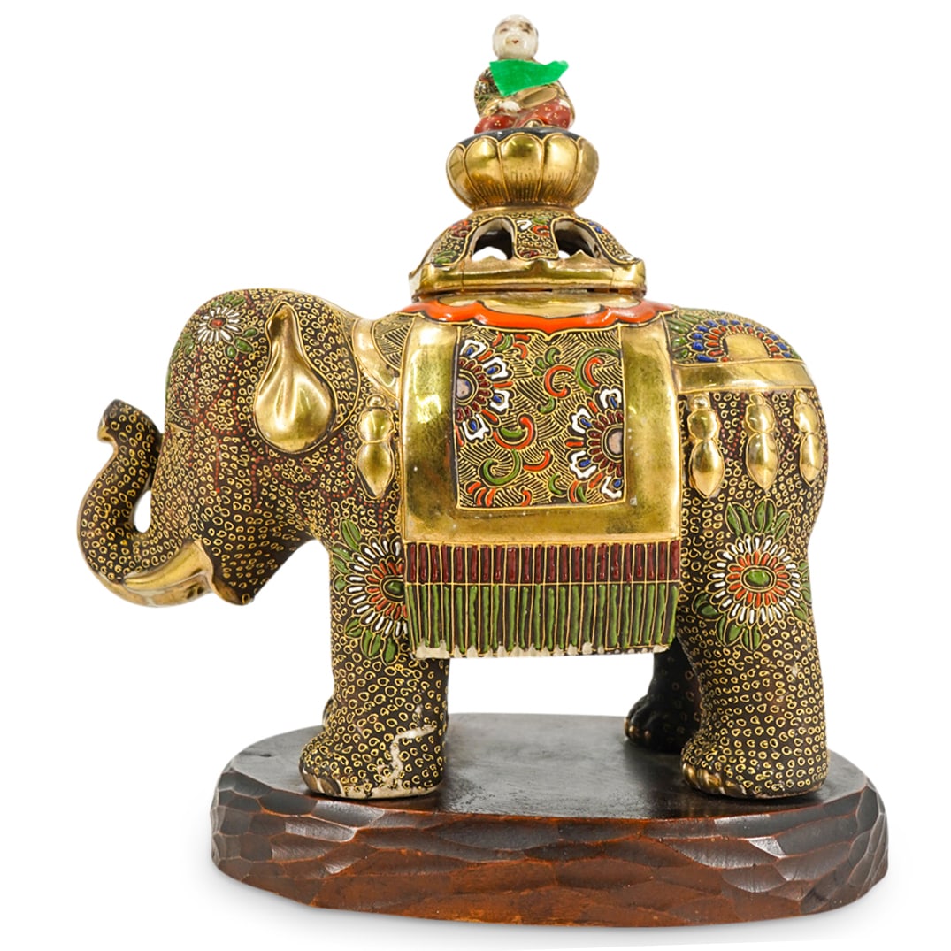 Japanese Satsuma Porcelain Elephant Jar: DESCRIPTION: Japanese polychrome Satsuma porcelain jar in the form of an elephant featuring floral and foliage motifs, gilt accents, and finial in the form of a figure seated atop a lotus base. Mounte
