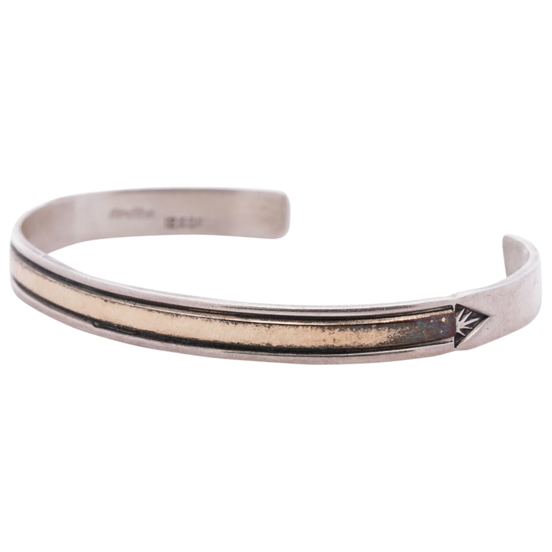 Native American 12k Gold Filled and Sterling Silver Cuff: DESCRIPTION: A Native American sterling silver cuff inlaid with 12k gold along the center stylized with plant motif terminals. Stamped "12kgf Sterling". Total Weight: 10.7 Grams CIRCA: 20th Cent. ORIG