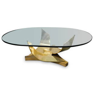 Ron Seff Brass "Coronet" Cocktail Table: DESCRIPTION: Ron Seff, rare and important brass "Coronet" cocktail table. The table base is brass with curved composition. Comes with oval glass table top. CIRCA: 1970s ORIGIN: USA DIMENSIONS: (Base)