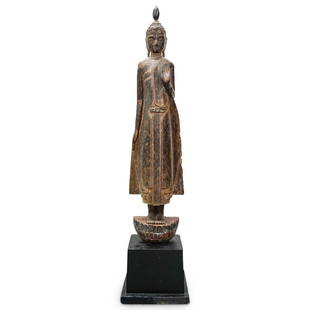 Antique Southeast Asian Carved Wooden Standing Buddha Sculpture: DESCRIPTION: Antique Southeast Asian, probably Thai, carved wood sculpture depicting Buddha Shakyamuni standing, atop a lotus base, the proper left hand in abhaya mudra. Mounted atop a wooden base. CI