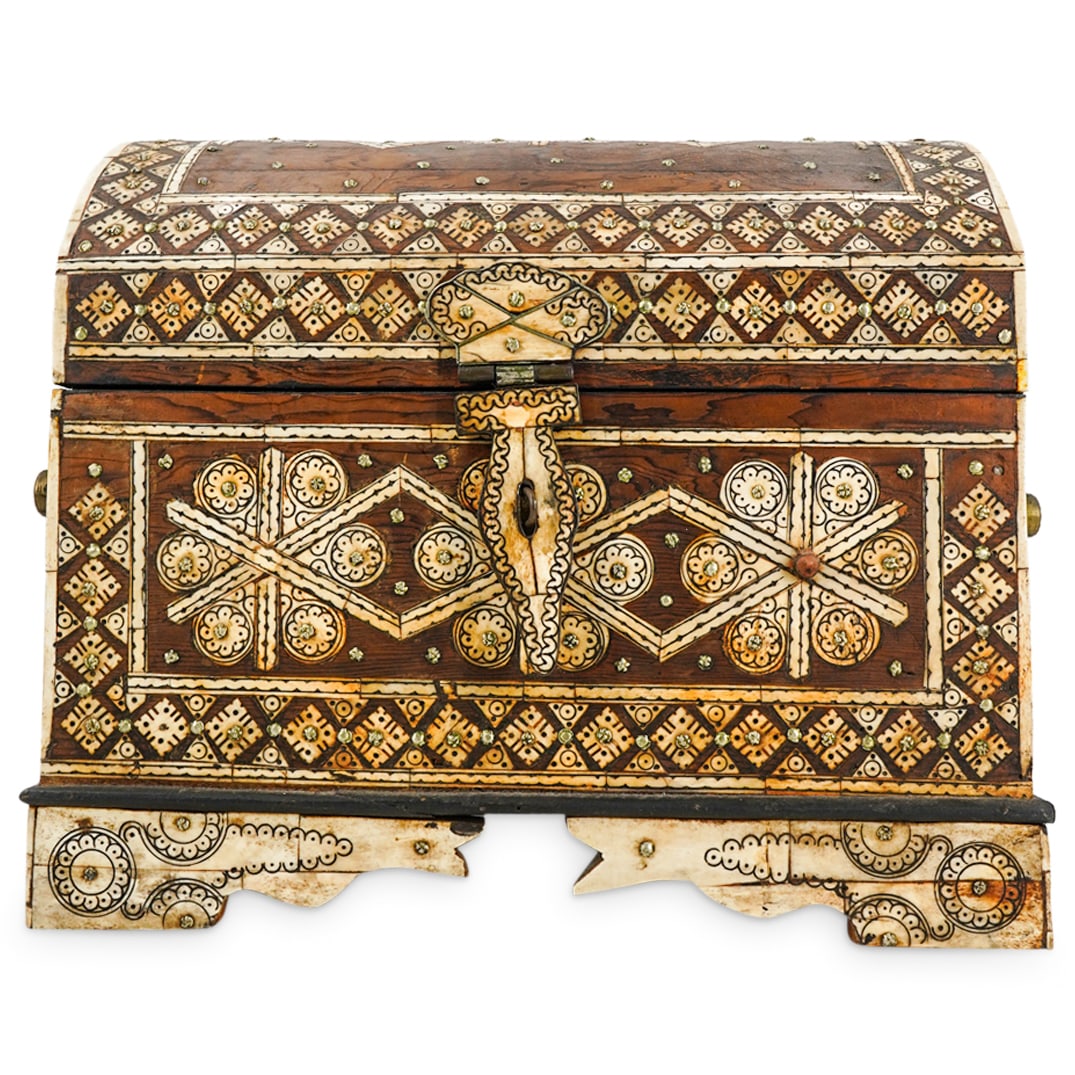 Antique Moroccan Carved Wood Parquetry Chest: DESCRIPTION: Moroccan carved wood chest inlaid with bone geometric patterns and crafted with a domed lid and rectangular trunk flanked by resin handles. Interior is leather lined and lid is fitted wit