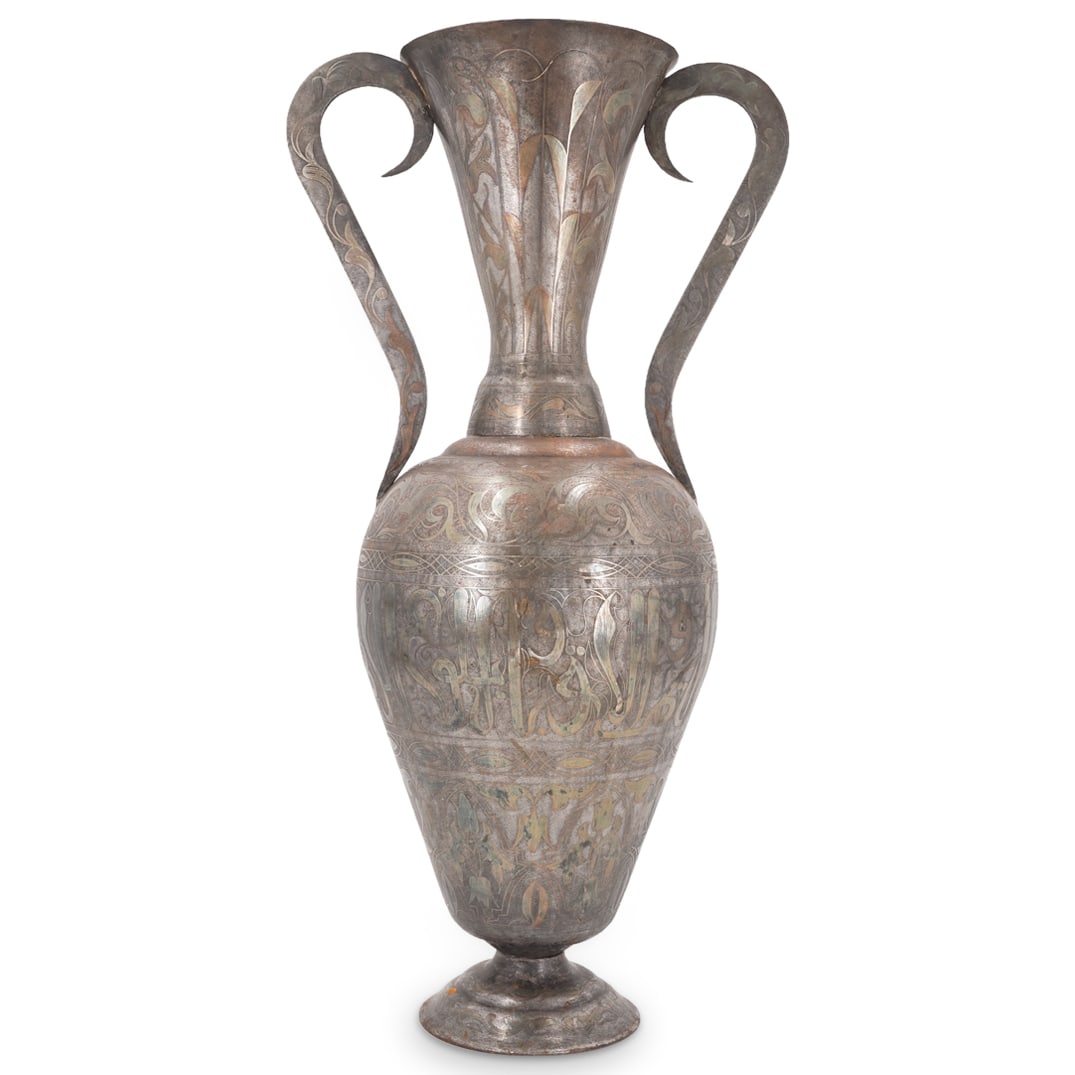 Antique Islamic Damascened Overlay Iron Amphora Vase: DESCRIPTION: Antique iron vase crafted in an amphora form and featuring damascened inscriptions in Arabic bordered by foliage patterns. CIRCA: 19th to early 20th Century ORIGIN: Ottoman Empire DIMENSI