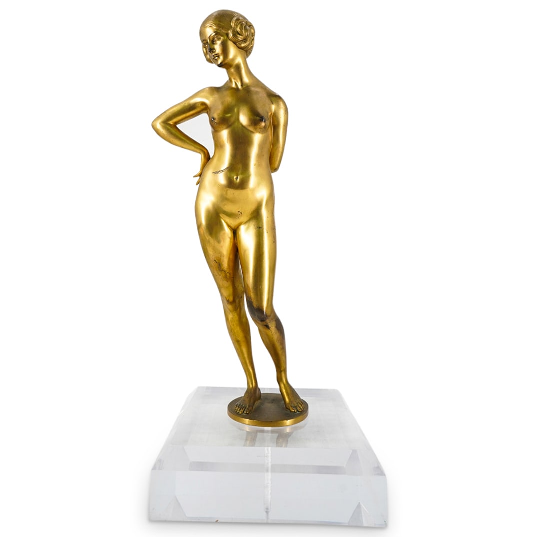 Art Deco European Gilt Bronze Nude On Lucite Base: DESCRIPTION: Finely crafted and highly detailed Art Deco gilt bronze sculpture depicting a nude woman leaning forward with right hand on hip, left hand behind back, and hair in two cinnamon buns over