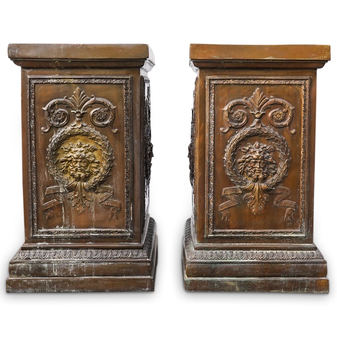 Pair of Neoclassical Style Patinated Metal Pedestals: DESCRIPTION: Pair of Neoclassical style patinated metal pedestals, each decorated with masks within a wreath with scrolled decorations. CIRCA: 20th Cent. ORIGIN: European DIMENSIONS: H: 29.25" x W: 17