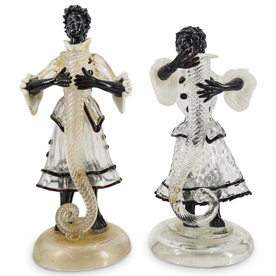 Pair of Barovier & Toso Murano Glass Female Horn Bearers: DESCRIPTION: Two matching Arte Vetraria Muranese Murano glass sculptures, each of a woman bearing an empty cornucopia fashioned as a candle socket. Each figure's skin and har are crafted in dark purpl