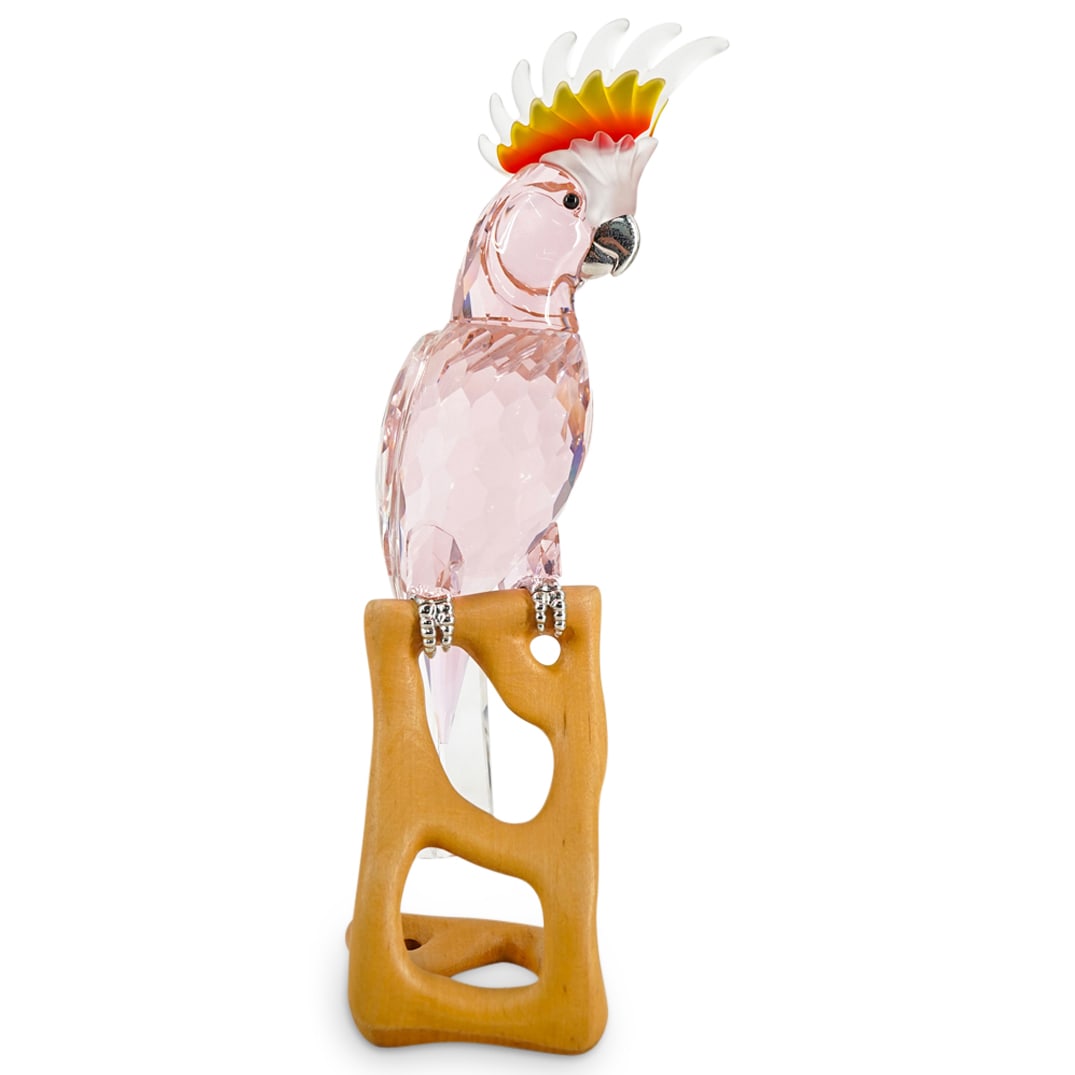 Swarovski Crystal "Cockatoo" Figurine: DESCRIPTION: A Swarovski Crystal "Cockatoo" figurine from the Paradise Bird Collection. This multifaceted Swarovski crystal Cockatoo bird has a pastel pinkish coloration. The figurine rest atop a wood