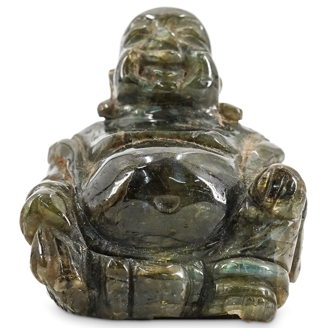 Chinese Carved Labradorite Budai: DESCRIPTION: Carved labradorite sculpture depicting a seated Budai bearing his cloth sack in his right hand. CIRCA: 20th Century ORIGIN: China DIMENSIONS: H: 2.5" W: 2.25" L: 2.25" CONDITION: Tiny scu