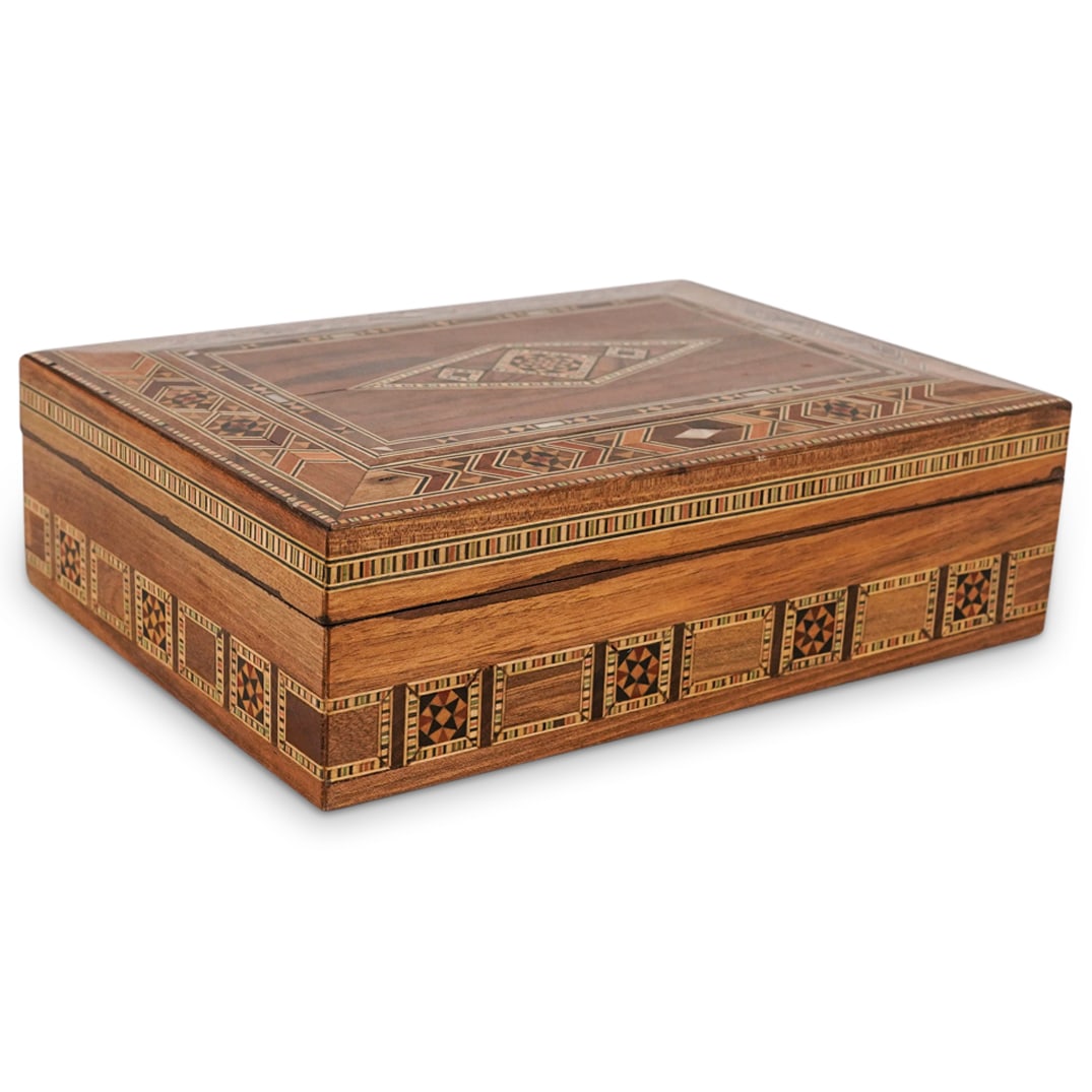 Syrian Damascene Marquetry Wooden Hinged Treasure Box: DESCRIPTION: Syrian Damascene inlaid bone and mother of pearl marquetry wooden hinged box decorated with characteristic decorative marquetry motifs. Finished with red fabric interior. CIRCA: 20th Cent