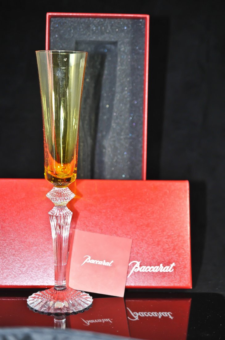 Baccarat crystal champagne flute by Mathias: DESCRIPTION: Limited edition Baccarat (amber orange) colored crystal champagne flute by famous designer Mathias, footed on a clear cut crystal steam. Never used and comes in original Baccarat box. Hal