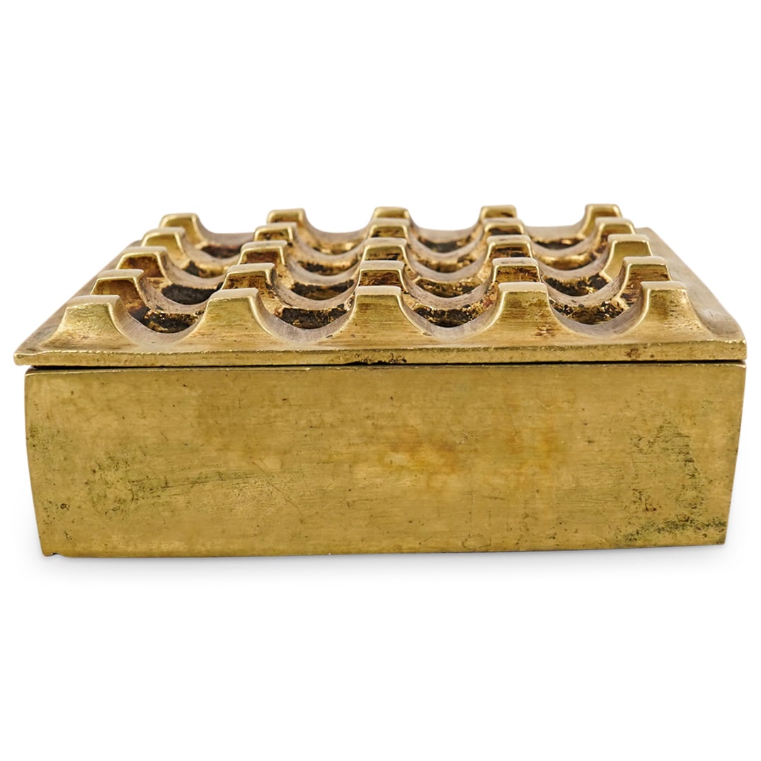 Ultima Ashtray by Backstrom & Bo Ljungberg For Pascha Ab Sweden: DESCRIPTION: Ultima ashtray by Backstrom & Bo Ljungberg for Pascha Ab Sweden, features a square form with pierced grid lid. CIRCA: Mid 20th Cent. ORIGIN: Sweden DIMENSIONS: H: 2" x W: 5.5" x L: 5.5" C