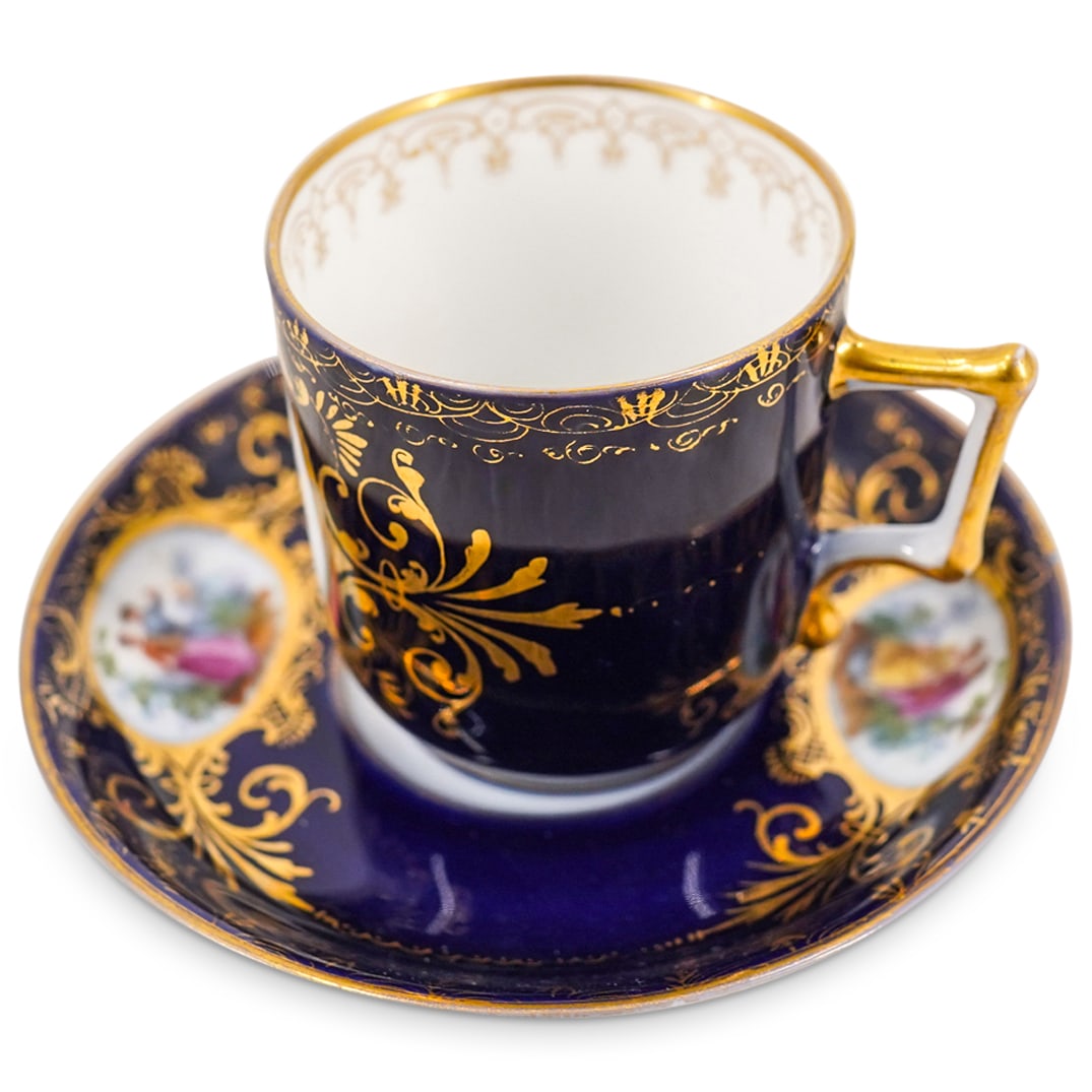 Royal Vienna Demitasse Cup and Saucer: DESCRIPTION: Royal Vienna porcelain demitasse cup with attached handle and matching saucer, painted with romantic scenes on a cobalt blue ground and gold enamel. Marked with the Beehive Mark on the bo