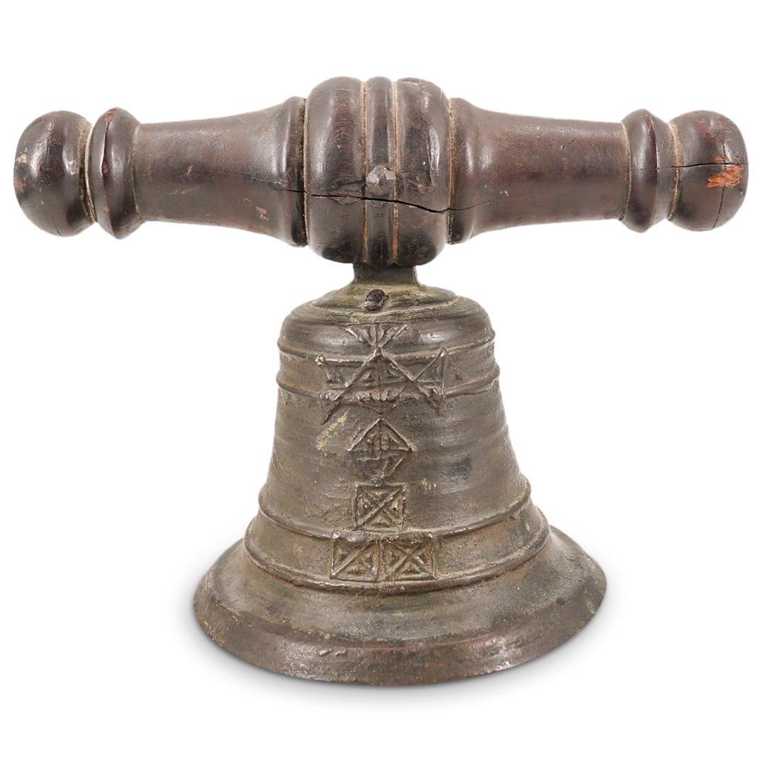 Antique European Bronze And Wood Church Bell: DESCRIPTION: Antique church bell composed of a bronze body fastened to a turned wooden bar and sporting a cross composed of triangular marks CIRCA: 19th Century ORIGIN: European DIMENSIONS: H: 8.25" W