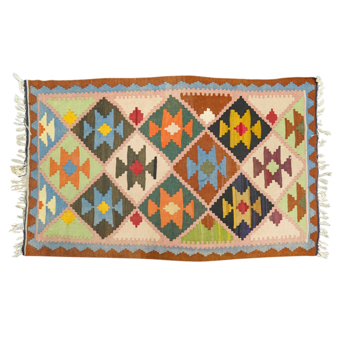 Middle Eastern Nomadic Tribal Wool Kilim Rug: DESCRIPTION: Middle Eastern Nomadic Tribal Wool Kilim Rug. With geometrical designs in a combination of brown, green, orange and blue colors. Finished with fringes on lateral sides. CIRCA: 20th Centur