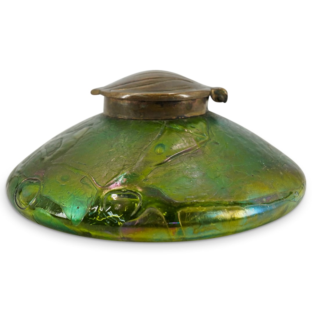 Loetz Art Glass Inkwell: DESCRIPTION: Loetz art glass inkwell with conical and purple threading with a brass top as stylized leaves. CIRCA: 20th century. ORIGIN: Unknown DIMENSIONS: H: 2.125" D: 5.25" CONDITION: Excellent con