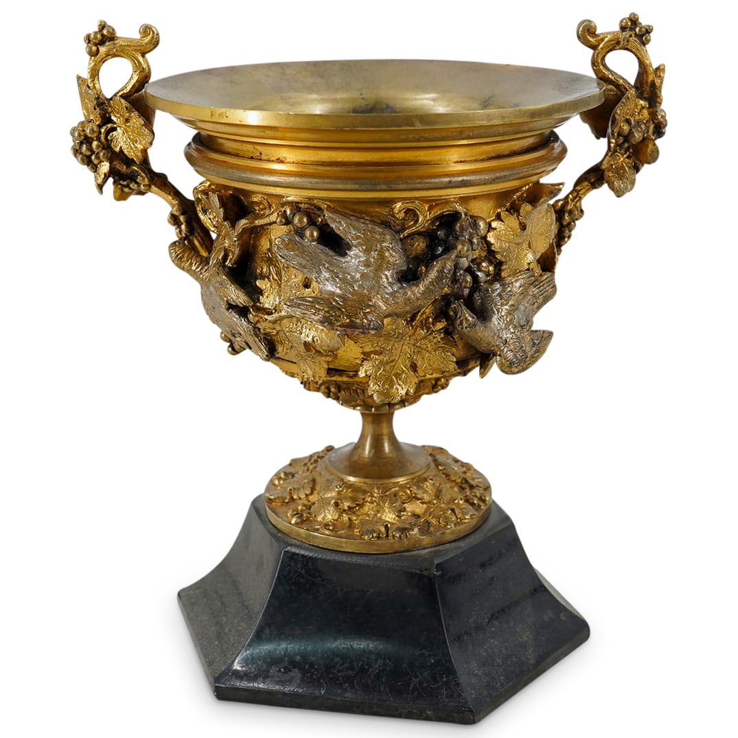 Antique European Grand Tour Gilt Bronze Urn: DESCRIPTION: Antique grand tour urn crafted from gilt bronze and featuring handles laden with grape clusters and handles extending from a ring of grapevines plucked by foraging birds around the urn bo