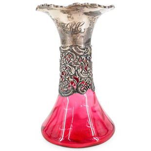 William Comyns Sterling Silver And Cranberry Glass Vase: DESCRIPTION: Cranberry glass vase with a silver collar and lip by William Comyns & Sons Ltd featuring open-work floral, foliage, and lattice designs around neck and flowers and foliage in high relief