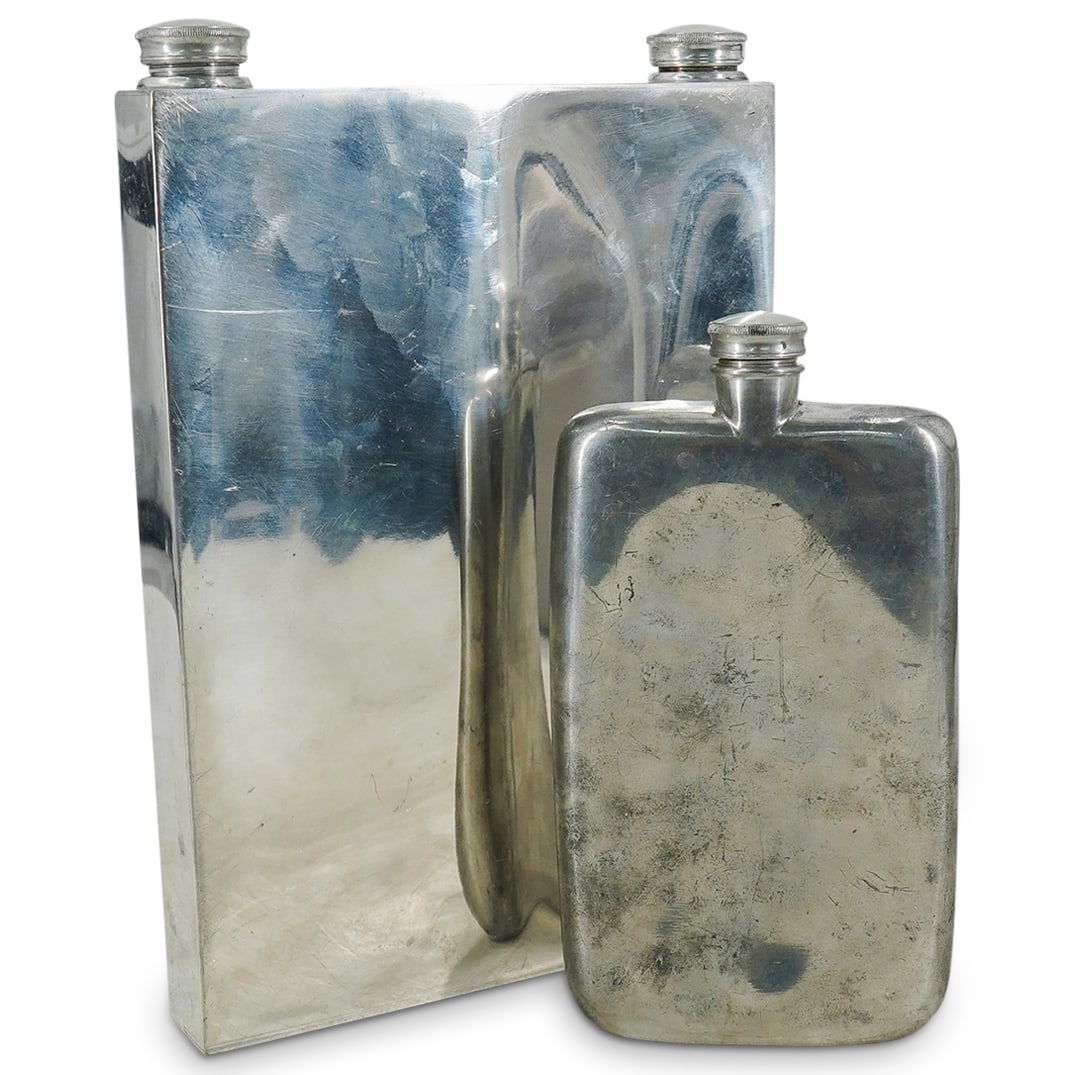 (2) Abercrombie & Fitch Silver Plated Flasks: DESCRIPTION: (2) Abercrombie & Fitch silver plated whiskey flasks with screw down caps, Americana-British Colonial style. (1) Smaller of the two, 12 oz, stamped, "Abercrombie & Fitch, New York, Made i