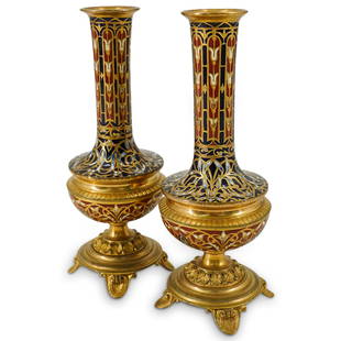 Pair Of Attr. To Barbedienne Champleve Blue, White, And Red Bud Vases: DESCRIPTION: Two matching champleve bud vases attributed to Barbedienne, each featuring enameled flowers and foliage in shades of red, white, and blue and sporting gilt outlines and gilt, four-footed