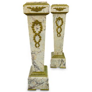 Pair of Empire Style Ormolu Bronze Mounted Marble Pedestals: DESCRIPTION: Pair of Empire Style pedestals featuring in a white to purple marble foundation fitted with ornate ormolu bronze decorations and bronze bordering. CIRCA: Late 19th Cent. ORIGIN: France DI