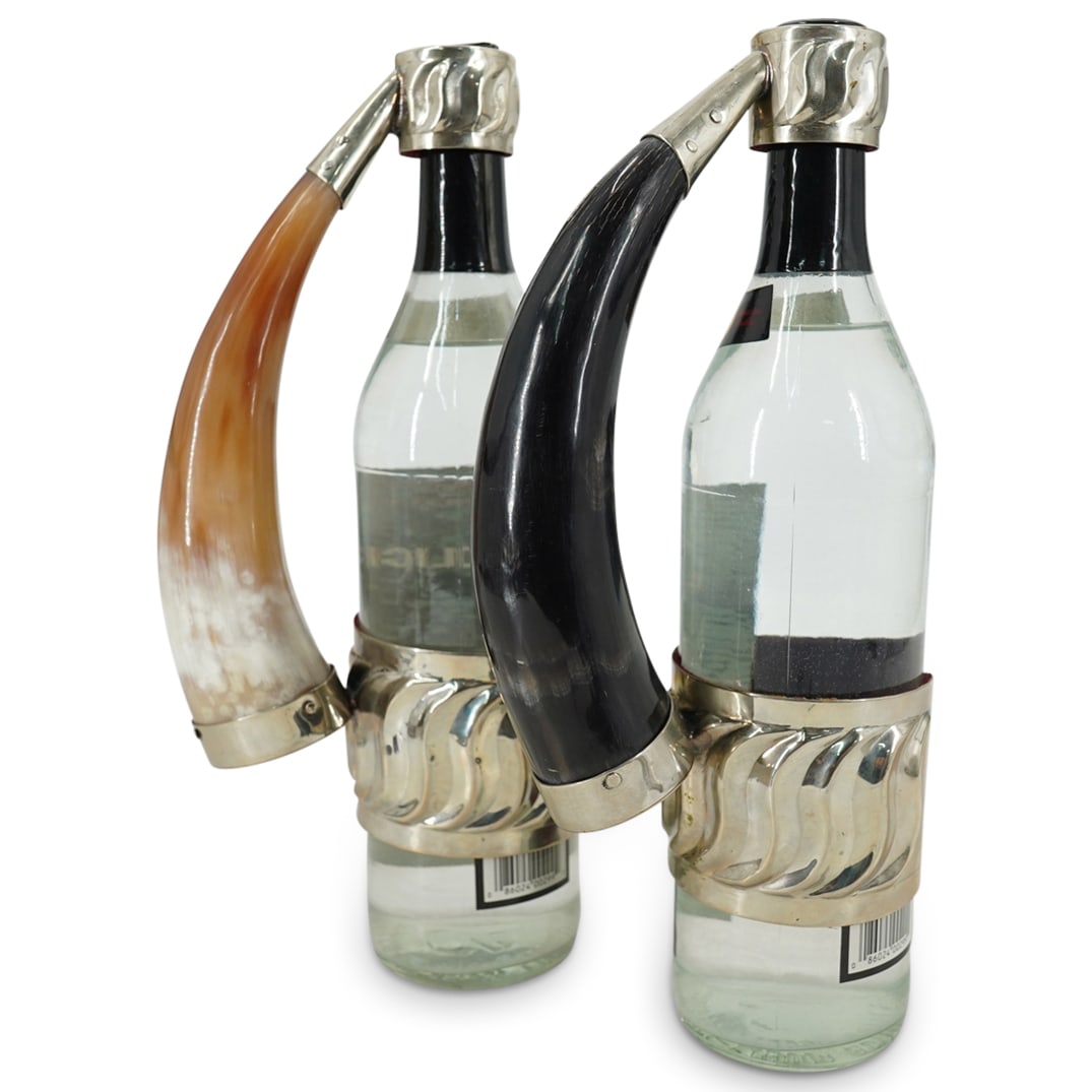 (2 Pc) Pair of Argentinian Goat Horn Wine Bottle Holders: DESCRIPTION: (2 Pc) Pair of Argentinian Goat Horn Wine Bottle Holders. Made by artisans from Argentina, using traditional goldsmith techniques. Designed with a goat horn and silver-plate accents. CIRC