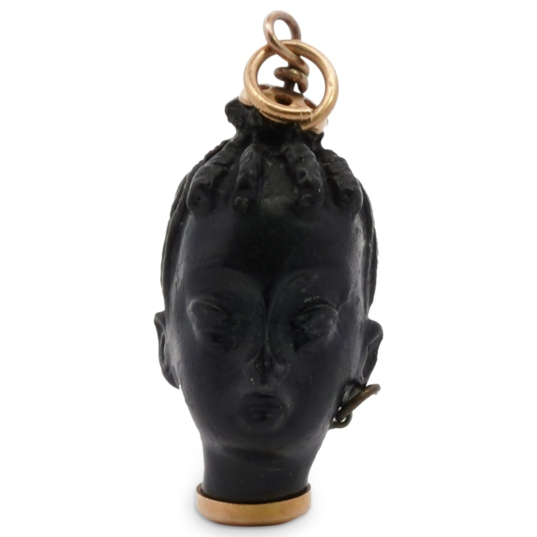 Italian 18k Gold and Carved Blackamoor Charm: DESCRIPTION: An Italian Blackamoor charm comprised of ebony carving fitted with a yellow gold bale and bottom cap, incised "Italy 18k". Total Weight: 1.53 Grams (.98 dwt) CIRCA: Mid 20th Cent. ORIGIN: