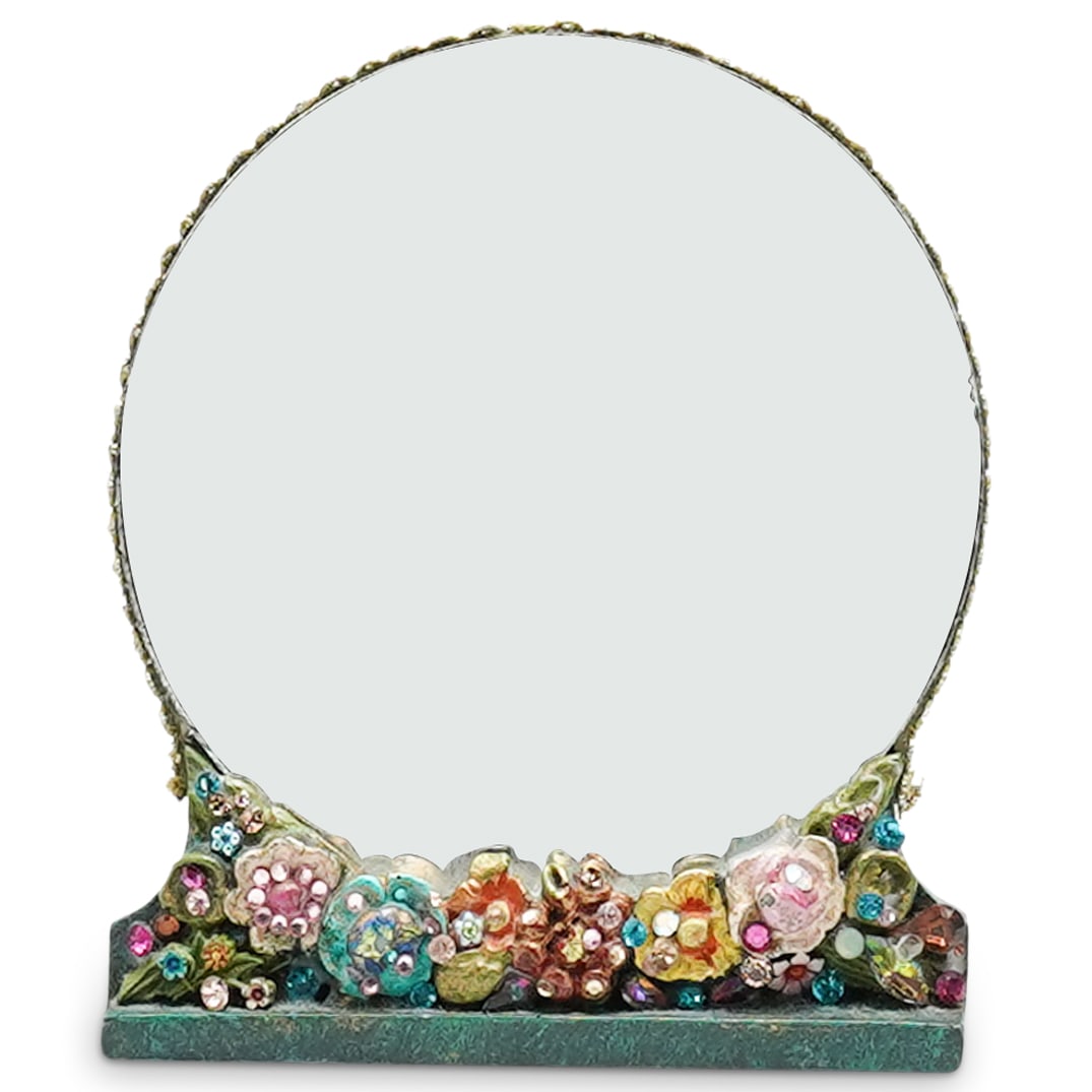 Bejeweled Table Mirror: DESCRIPTION: Circular table mirror featuring floral motifs and polychrome crystals. CIRCA: Late 20th - early 21st century ORIGIN: Unknown DIMENSIONS: H: 6.25" W: 5.25" Depth: 2" CONDITION: Minor chips