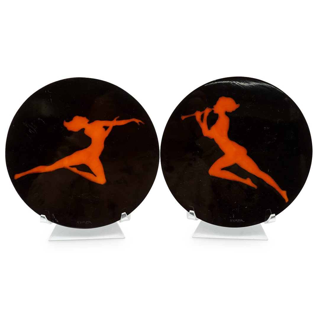 Pair Of Art Deco Nude Profile Disc Plaques W/ Stands, Signed Hymer: DESCRIPTION: Two matching plaques, each featuring a nude performer in amber- one a dancer, one a musician - within a composite plaque crafted as a disc. Each piece is signed "HYMER" and includes a luc
