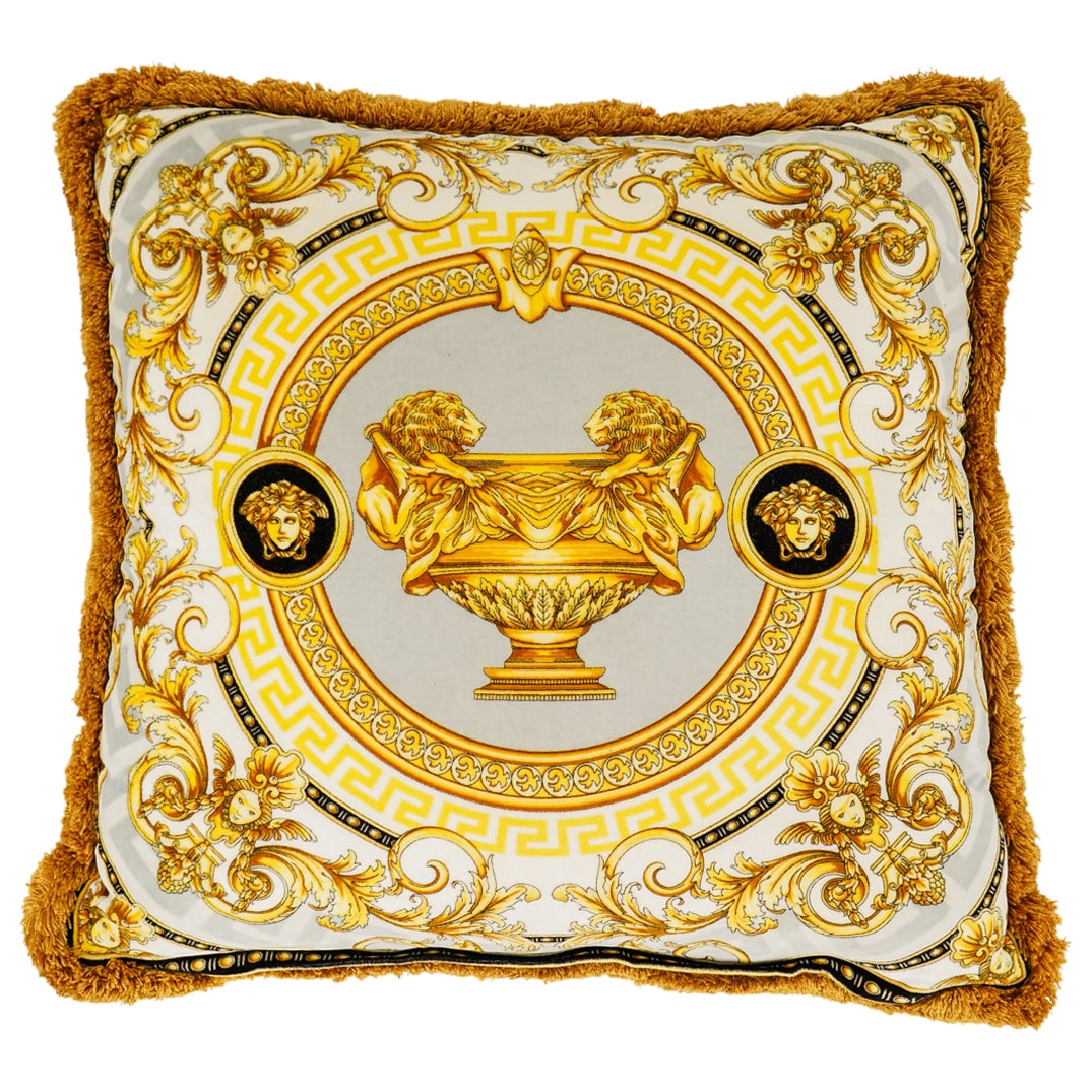 (2 Pc) Versace Designer Grey, White, And Gold Pillow: DESCRIPTION: (2 Pc) Versace plush pillow featuring a central lion-handled gilt urn design against a grey background bordered by gilt foliage and sporting ruffled edges. Includes clear plastic dust bag