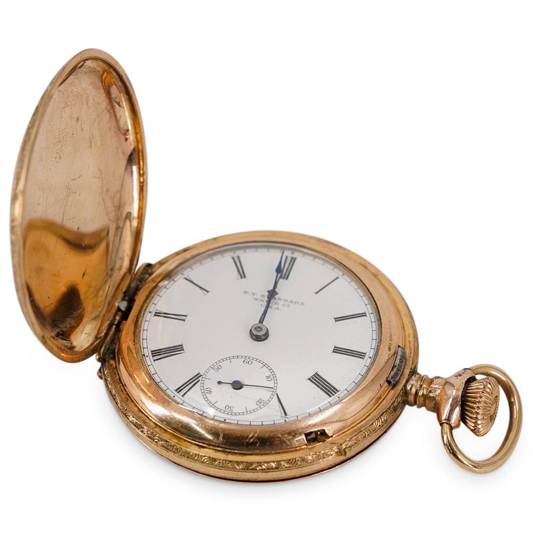 Antique New York Standard Watch Co. Gold-Plated Pocket Watch: DESCRIPTION: Antique New York Standard Watch Co. gold-plated pocket watch. With white dial and black Roman numerals. Numbered 5599380. With floral engraved motifs. CIRCA: 1880-1889 ORIGIN: USA DIMENSI