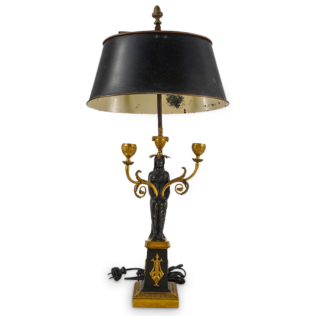Antique French Neoclassical Bronze And Metal Table Lamp: DESCRIPTION: Double socket, electric table lamp composed of a bronze base fashioned as a plinth adorned on the sides with lyres and wreaths and supporting a semi-nude woman carrying two foliage form c