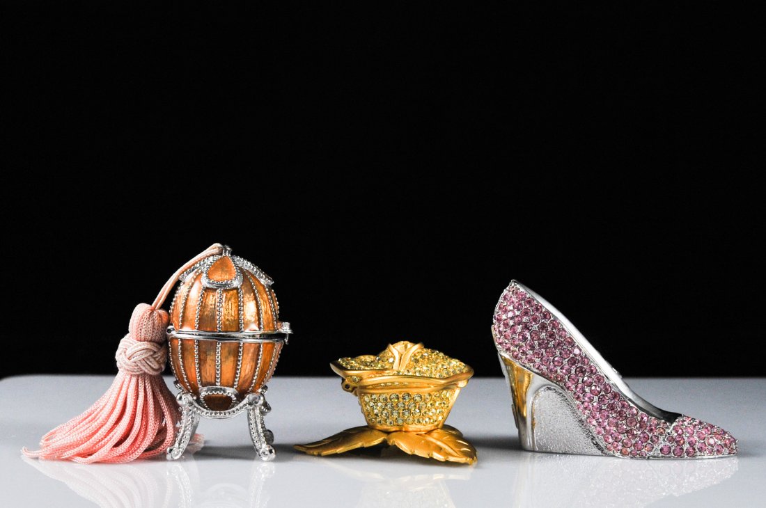 Lot of three Estee Lauder solid perfume jeweled bo: DESCRIPTION: Three Estee Lauder collectors perfume boxes with solid perfume inside. Features the "glass slipper" with pink rhinestones, the "jeweled flower" with white rhinestones, and an enameled egg