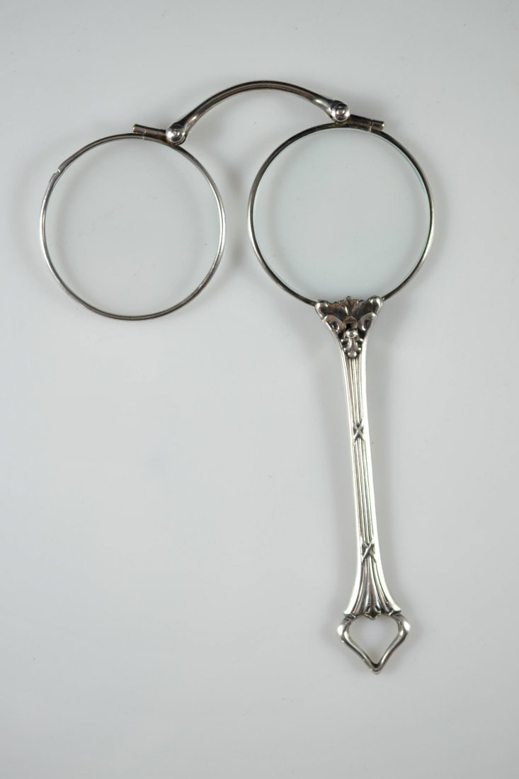 Sterling mechanical fold away handheld lenses: DESCRIPTION: Sterling mechanical lenses. Magnifying glass design which separates the lenses with a lever to create a pair of handheld glasses. Very unique. Sterling handle and lens frames. Tested ster