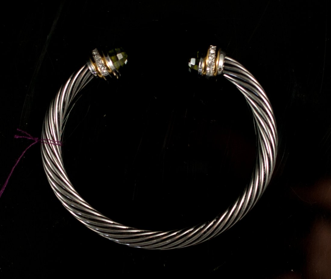 David Yurman style stainless bangle bracelet: DESCRIPTION: David Yurman style bangle bracelet. Features a stainless steel twisted design. Each end is capped with small rhinestones, 18k gold accent and two faceted cabochon stones with a smokey top