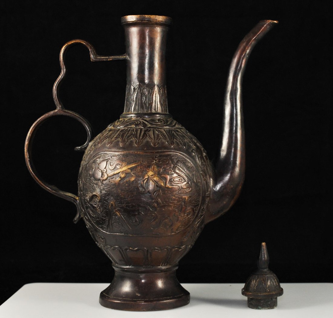 Antique Chinese bronze figural teapot. Signed: DESCRIPTION: Chinese bronze figural teapot. Solid bronze high spout design. Decorated with raised bronze design of village people on one side and miscellaneous symbols on the reverse side. Features a 
