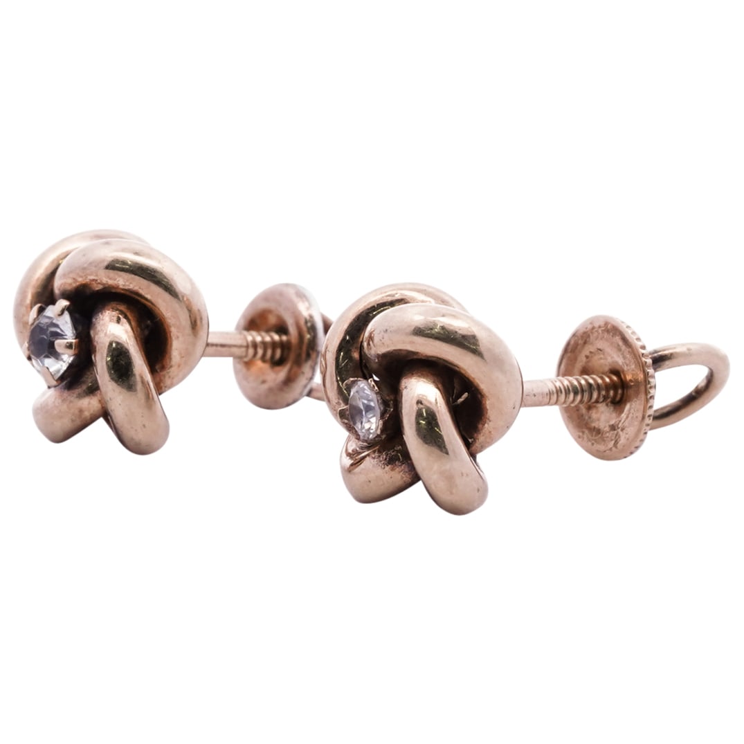 Pair of 14k Yellow Gold & Diamond Studs: DESCRIPTION: Pair of yellow gold studs with knot form and (0.10cts) diamond inset centers, completed with screw backs. CIRCA: 20th Cent. ORIGIN: Italy DIMENSIONS: Dia: 9.1 MM (Total Weight: 1.29 Dwt.)