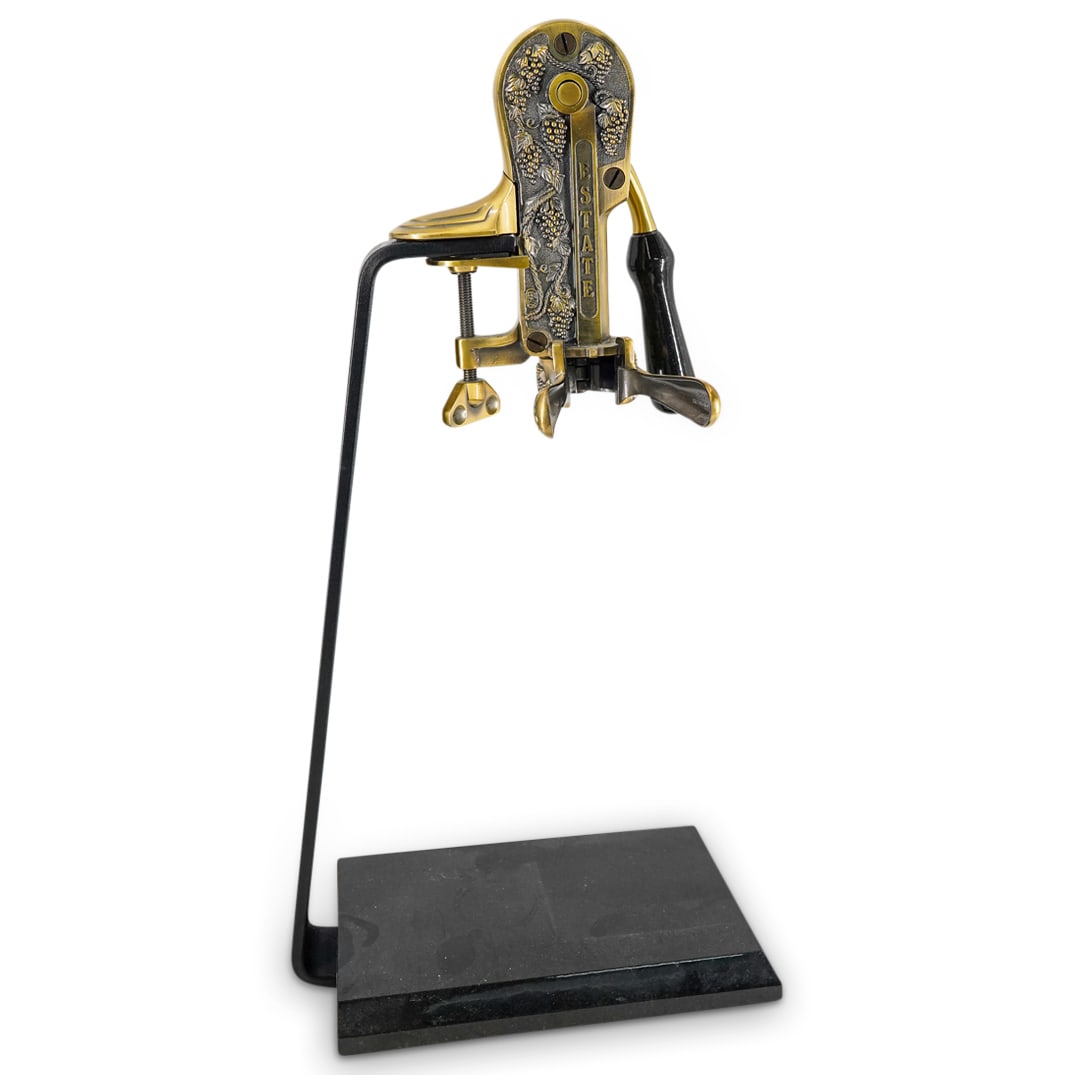 Vintage Rogar Vintner's Standing Wine Bottle Opener: DESCRIPTION: Vintage Rogar vintner's standing wine bottle opener featuring grapevine motifs in high relief on the opener proper, an iron stand, and a base sporting a black veneer. CIRCA: 20th Century