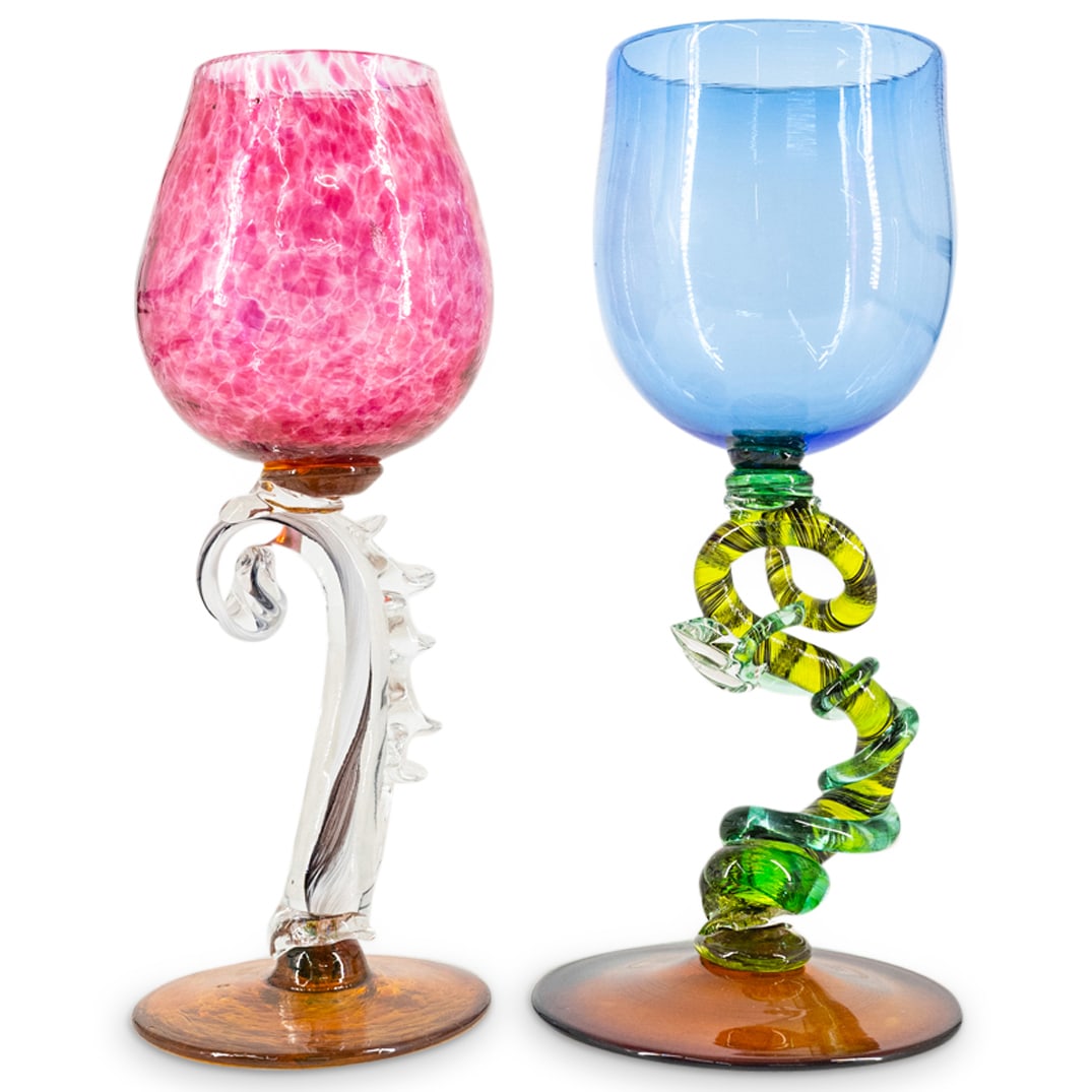 (2Pc) Art Glass Wine Goblets: DESCRIPTION: (2Pc) Art glass wine goblets with floral formed stems. CIRCA: 20th Cent. ORIGIN: USA DIMENSIONS: (H: 9.25" x D: 3.25") & (H: 9" x D: 3.5") CONDITION: Leaf broken and missing from single g
