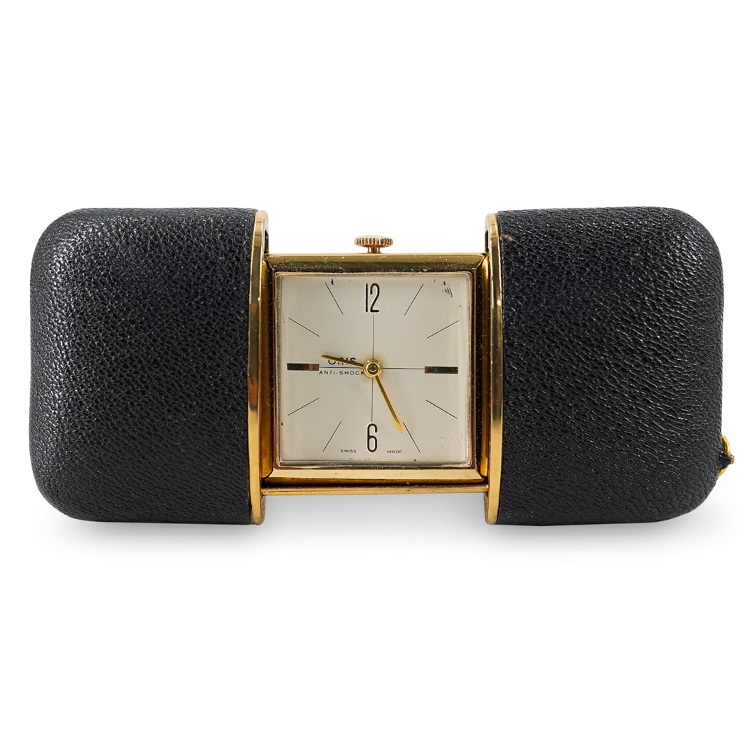 German Oris Ermeto Hand Wound Travel Clock: DESCRIPTION: Ermeto travel clock by Oris featuring a black textured case and gilt housing. Marked on underside with patent numbers (2640668 and 2719402) and "Made in Germany". Tested and fully functio