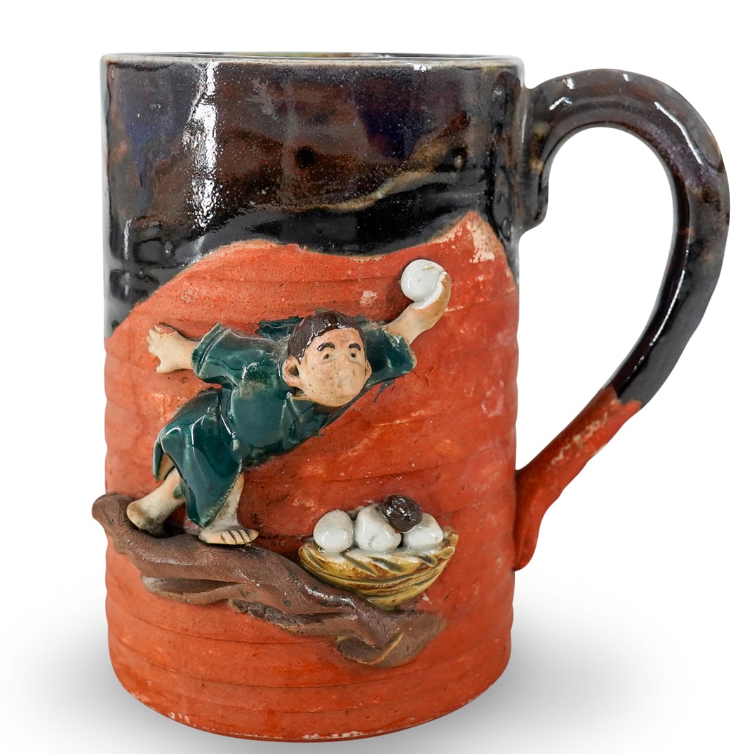 Antique Japanese Sumidagawa Ceramic Mug: DESCRIPTION: Antique Sumidagawa ceramic mug composed of a red clay coated around the lip and upper handle in a brown glaze giving way to green in mug interior and sporting an applied scene on exterior