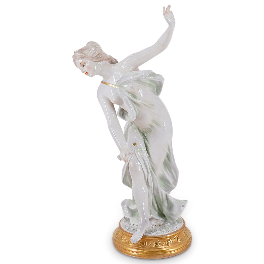 Antique Capodimonte Porcelain Dancer: DESCRIPTION: Antique porcelain Capodimonte figurine depicting a woman dancing in a long, gilt accented gown on a textured ground atop a gilt base. Hallmarked on underside. CIRCA: 1890s-1910s ORIGIN: I