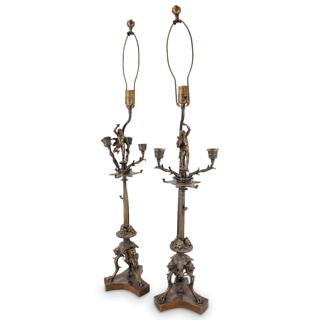Pair Of Converted Italian Bronze Candelabra Table Lamps: DESCRIPTION: Two matching single socket table lamps, each composed of a converted bronze, triple-socket, tripod candelabrum decked with foliage and drama masks and sporting a nude festive figure at it