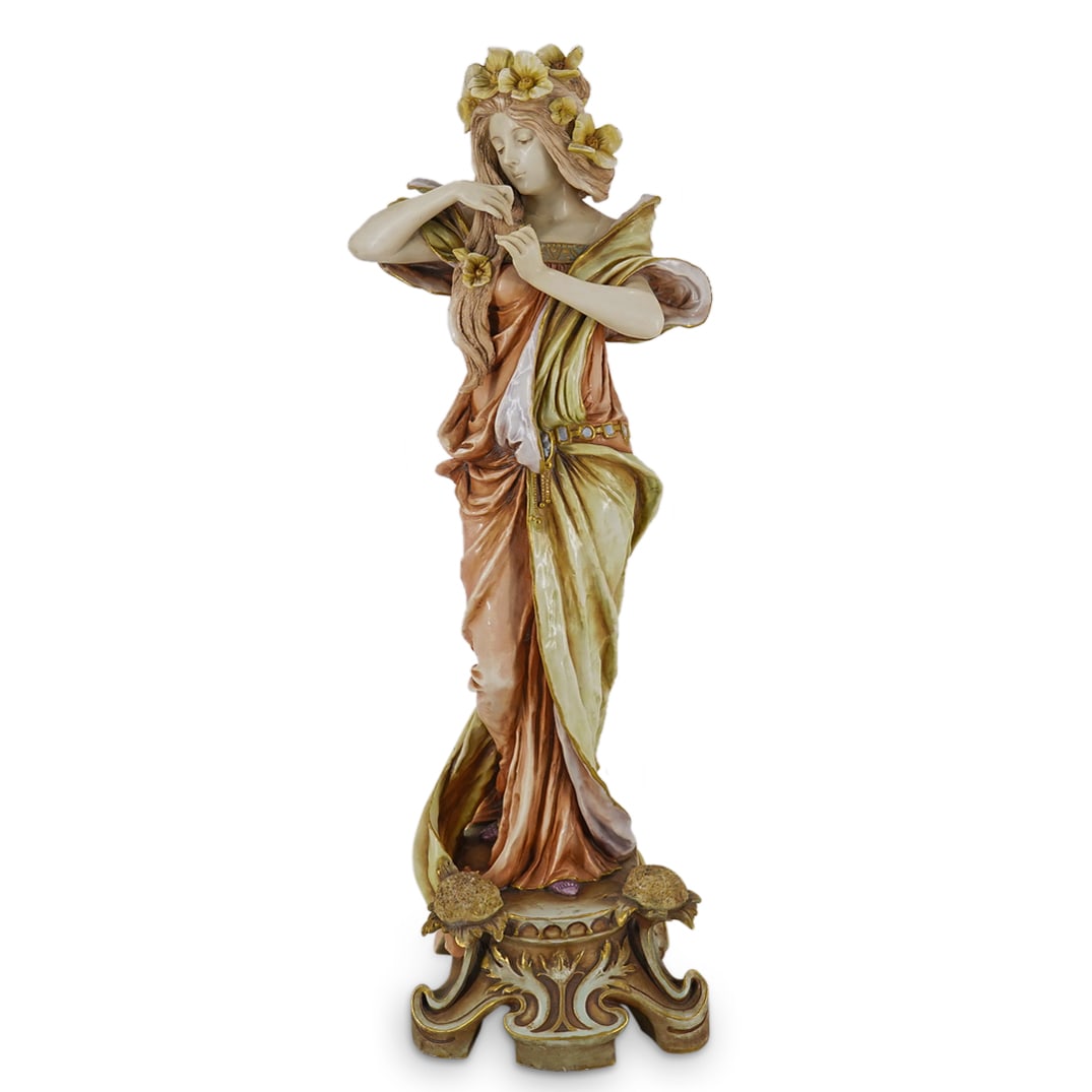 Albin Dobrich For Ernst Wahliss Art Nouveau Woman Figurine: DESCRIPTION: Porcelain figurine by Albin Döbrich (Austrian, 1872–1945) for Ernst Wahliss (Austrian, 1837–1900) depicting a woman in flowing robes placing yellow flowers in her hair and standing o